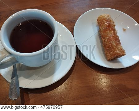 Bali Island - A Cup Of Warm Tea And A Piece Of Risoles As A Snack On A Small Plate