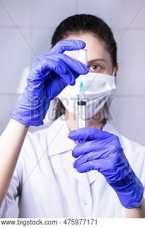 A Young Woman Doctor Draws Medicine From An Ampoule Into A Syringe.  Close-up.  Vaccination And Immu