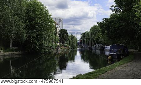 London - 05 21 2022: Boats Moored On The Grand Union Canal Near Elkstone Rd With The 4c Bridge In Th