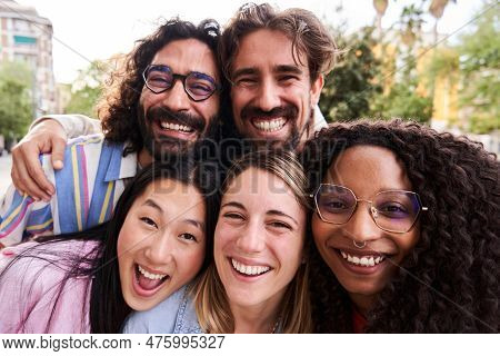 Close Up Portrait Of Group Of Multicultural Friends Looking At Camera Cheerfully With Heads Together