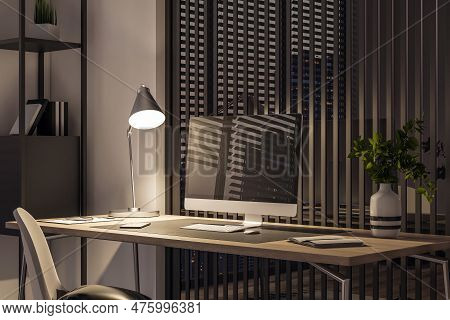 Side View Of A Wooden Home Desk With Blank Screen Modern Computer, With Glowing Lamp At Night On Mod