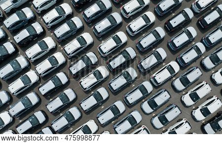 Aerial View Of New Cars Stock At Factory Parking Lot. Above View Cars Parked In A Row. Automotive In