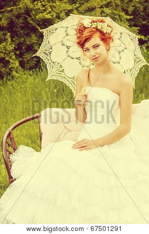 Beautiful smiling bride with chaming red hair. Wedding dress and accessories. Wedding decoration. 