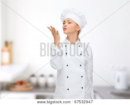 cooking, gesture and food concept - smiling female chef showing delicious gesture