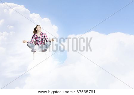 Young woman sitting on chair and meditating