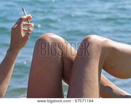 Woman Relaxes By The Sea Smoking  Cigarette