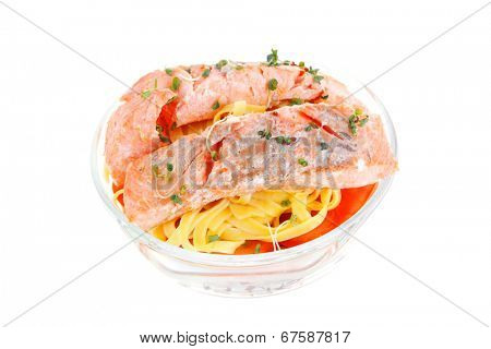 fresh fried natural pink salmon on italian traditional tagliatelle backed with tomato and vegetables isolated over white background