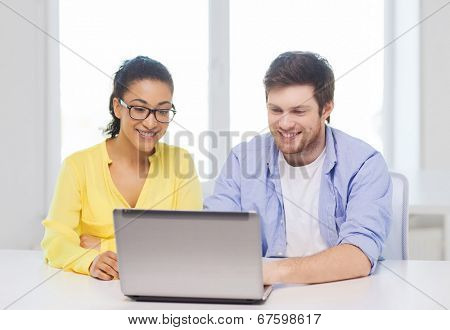 education, technology, business, startup and office concept - two smiling people with laptop in office