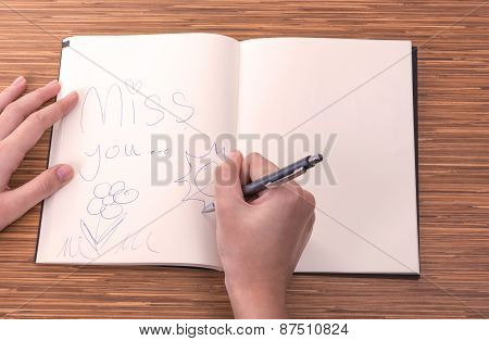 Female Hand Writing In Notebook On Table