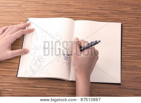 Female Hand Writing In Notebook On Table