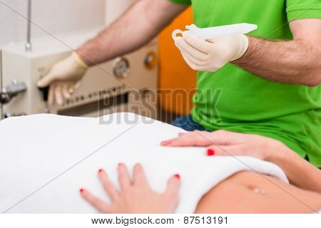 Woman at colon therapy with alternative practitioner lying on bench in practice