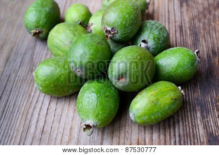 Green feijoa fruit on wooden table