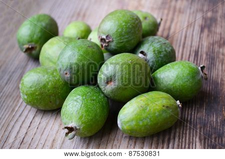 Green feijoa fruit on wooden table