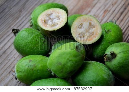 Green feijoa fruit on wooden table
