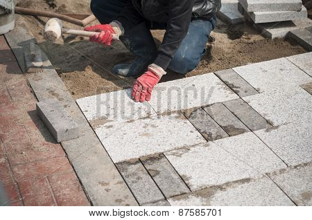 Construction Worker Installing The Pavestone