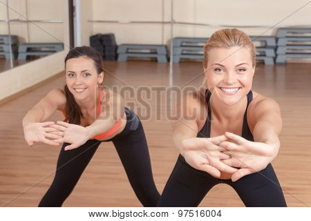 Pair f women stretching forward