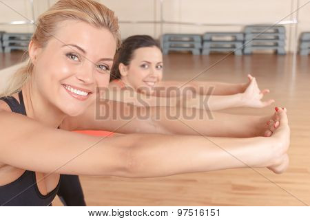 Pair f women stretching forward