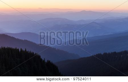 Distant Mountain Range And Thin Layer Of Clouds On The Valleys