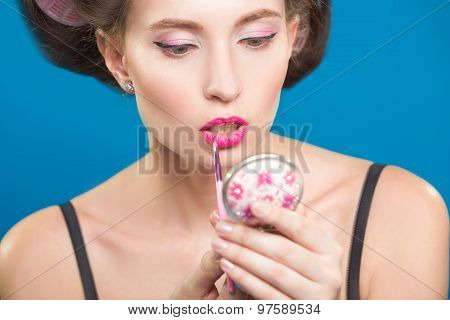 Sexy young pin-up girl doing make-up
