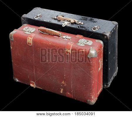 Closeup of two battered old suitcases against black background