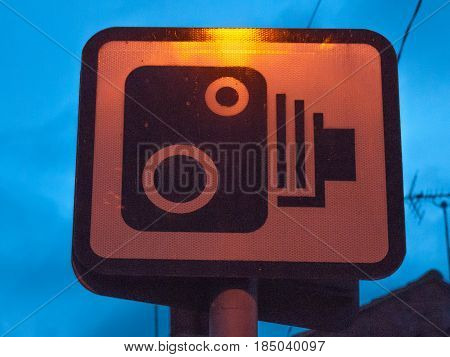 a sign outside at night of camera for speeding