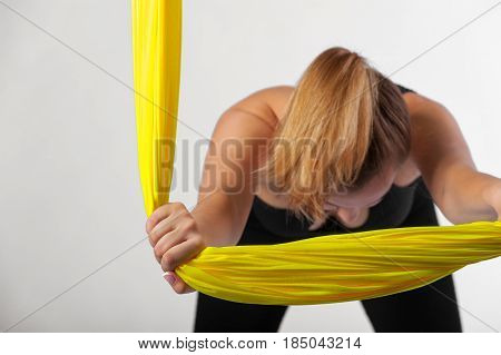 Cropped shot of young woman practicing fly yoga, studio shot. Body balance and antigravity exercises. Wellness and bodycare concept