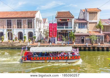 MALACCA, MALAYSIA - AUGUST 13, 2016: Cruise tour boat sails on the Malacca River in Malacca. Rehabilitation of the Malacca River to develop river tourism started in July 2002