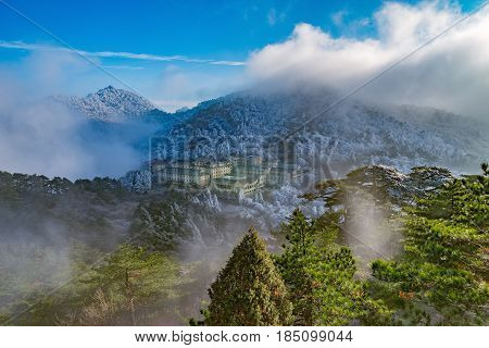 Clouds above the peaks and hotels of Huangshan National park. China.