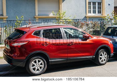 STRASBOURG FRANCE - APR 8 2017: Red Nissan Qashqai parked on street. The Nissan Qashqai is a compact crossover SUV produced by the Japanese car manufacturer Nissan since 2006.