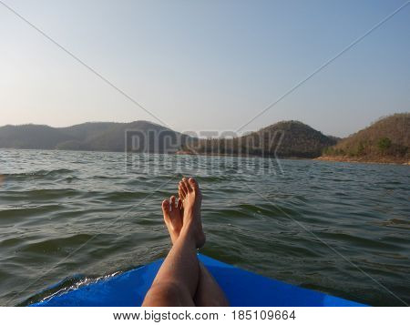 young woman sit relaxing with one's legs crossed. with big rubber pad float on water have scenery seasky and mountain are background. this image for naturetravel and seascape concept
