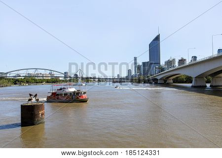 BRISBANE, AUSTRALIA - APRIL 29 2017: Brisbane CBD skyline and 1 William Street building with connecting Goodwill bridge and highway. Free City Hopper ferry commuting passengers on the Brisbane River