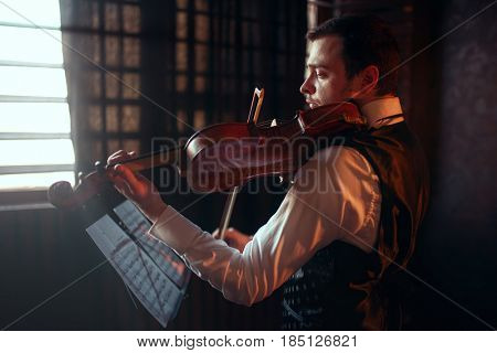 Male fiddler playing classical music on violin