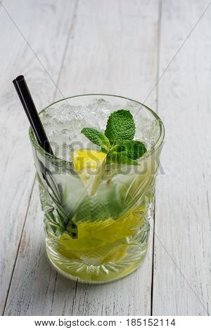 Mojito cocktail on white wooden background close up.