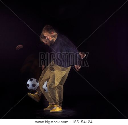 A portrait of a fan with ball on gray studio background. Freestile concept. Stroboscope shooting technique