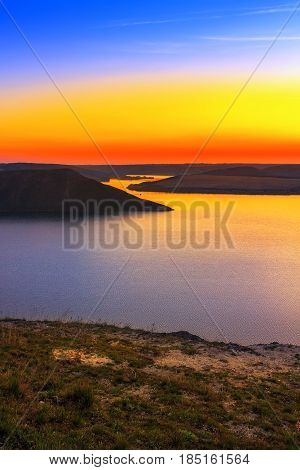 Magnificent sunset scenery on the Dniester river with colorful evening sky reflected in the water