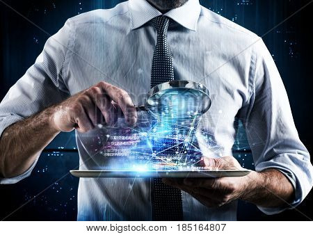 Man looks at the magnifying glass the screen of a tablet