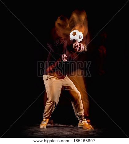 A portrait of a fan with ball on gray studio background. Freestile concept. Stroboscope shooting technique