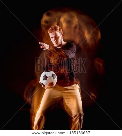 A portrait of a fan with ball on gray studio background. Freestile concept. Stroboscope shooting technique