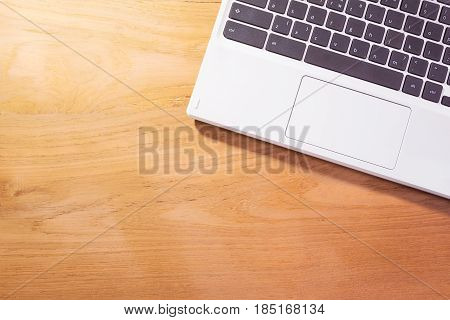 white laptop notebook computer on wooden table background with room for copyspace good for using as business theme background