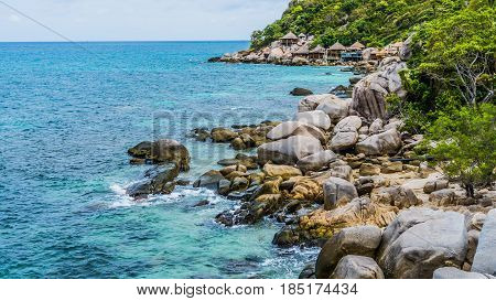 Costline of Koh Tao Islands in Thailand. Granite Rocks and blue clear water hitting Rocks. Thailand