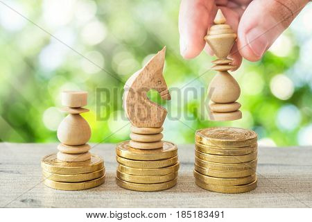 hand hold king chess on gold coins with tree bokeh and sun lightconcept growing investor.