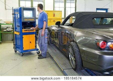 Auto Mechanic Doing The Wheel Alignment On His Garage