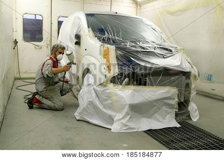 Worker Painting A Car On His Garage