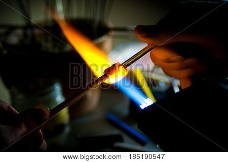 Glass Artist in her workshop making beads in the fire