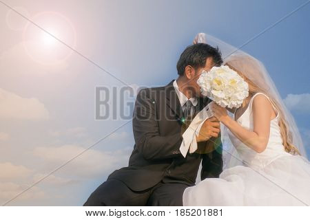 Groom and bride hiding behind the white rose flower Surprise wedding proposal concept.