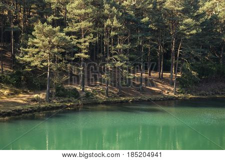 Beautiful Vibrant Landscape Image Of Old Clay Pit Quarry Lake With Unusual Colored Green Water