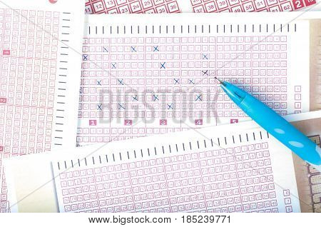 Person's Hand Marking Number On Lottery Ticket With Pen