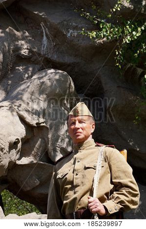 Fighter of Red Army in the form of times of World War II with the machine gun at a historical monument (fragment)