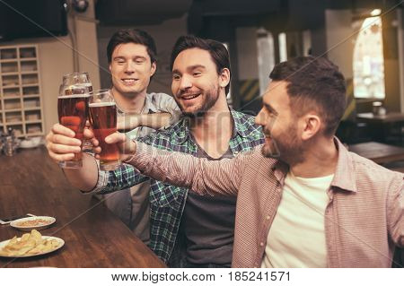 Football time. Friends spending time together in pub. Guys having fun while watching football. Men drinking beer
