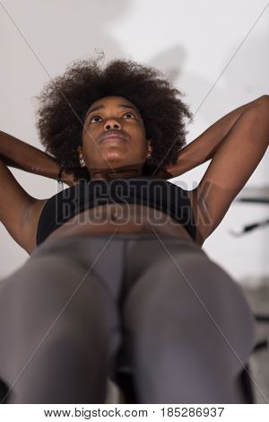 young fit african american woman doing sit ups in fitness studio at the gym.Abdominal exercises Sit up